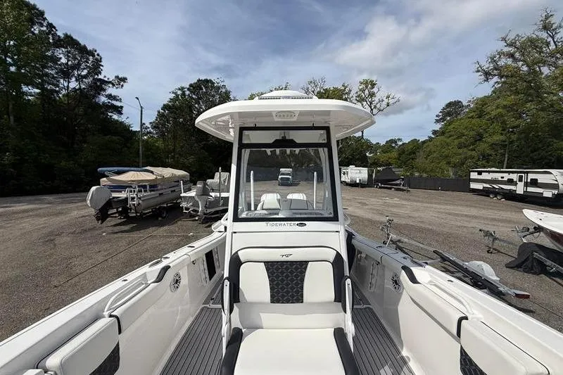 Slide: The Image of 2022 Tidewater 272 LXF boat in a parking lot with trees and trailers. - 30