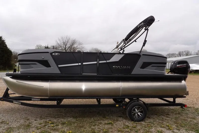Slide: The Image of 2026 Sylvan R-20 CLZ DH pontoon boat on trailer, featuring sleek design and Mercury outboard motor. - 11