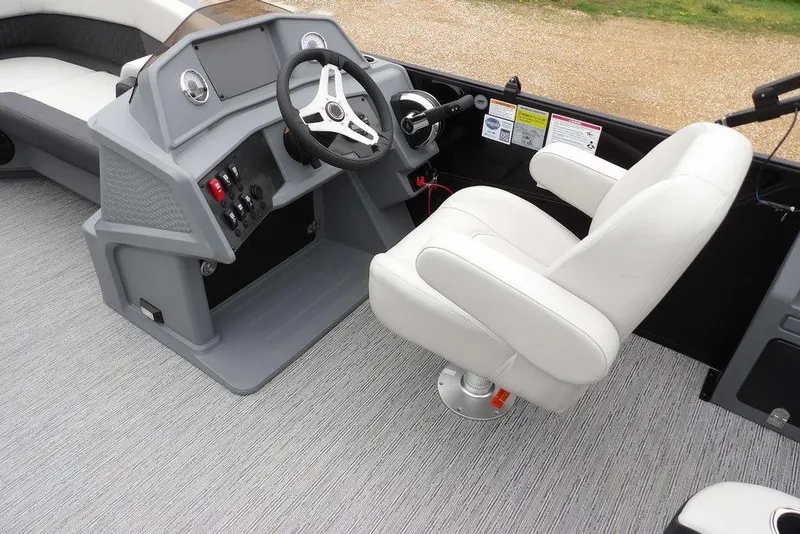 Slide: The Image of 2026 Sylvan R-20 CLZ DH boat interior with steering console and white captain's chair. - 9