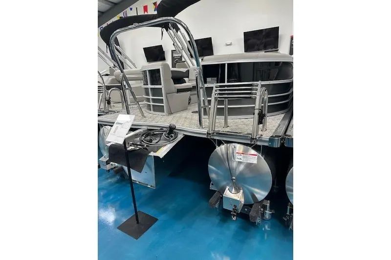 Slide: The Image of 2026 Berkshire 24RFX LE pontoon boat displayed indoors with seating and ladder. - 7