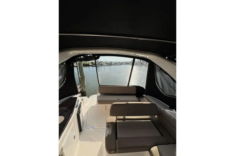 Slide: The Image of 2013 Regal 35 Express Cruiser interior with seating, overlooking marina view. - 10