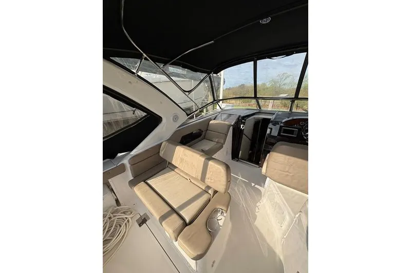 Slide: The Image of Interior of 2013 Regal 35 Express Cruiser with beige seating and black canopy. - 13