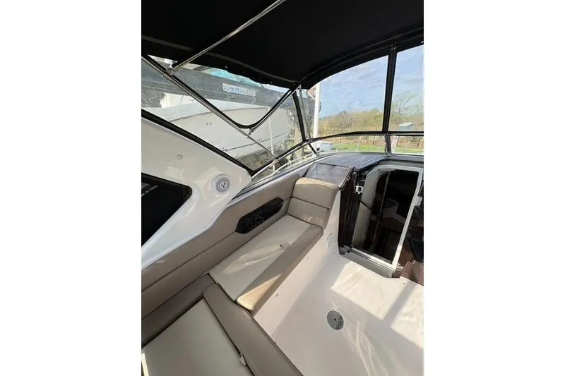 Slide: The Image of 2013 Regal 35 Express Cruiser interior with beige seating and black canopy. - 14