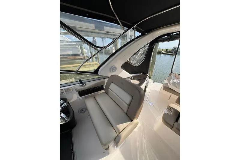 Slide: The Image of 2013 Regal 35 Express Cruiser interior with beige seating and water view. - 17