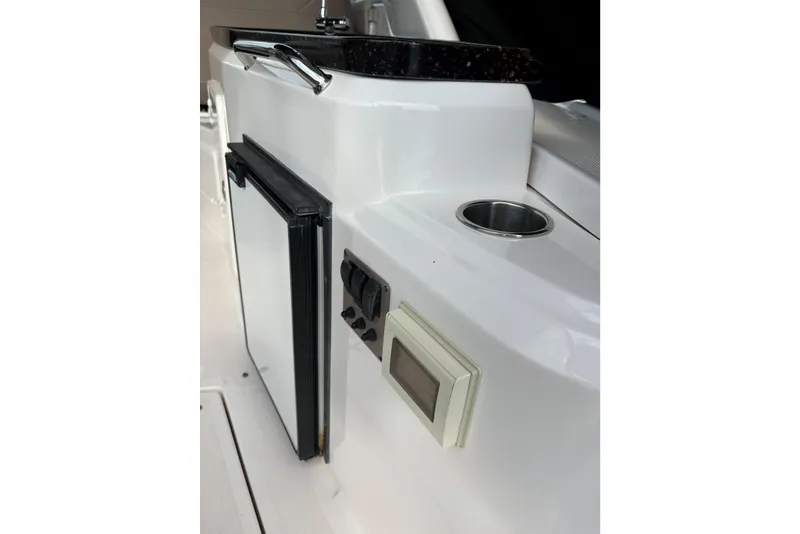 Slide: The Image of 2013 Regal 35 Express Cruiser interior with mini fridge and control panel. - 27