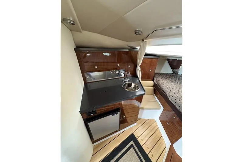 Slide: The Image of Interior of 2013 Regal 35 Express Cruiser with kitchenette and sleeping area. - 32