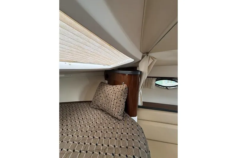 Slide: The Image of Interior cabin of 2013 Regal 35 Express Cruiser with patterned bedding and porthole window. - 34