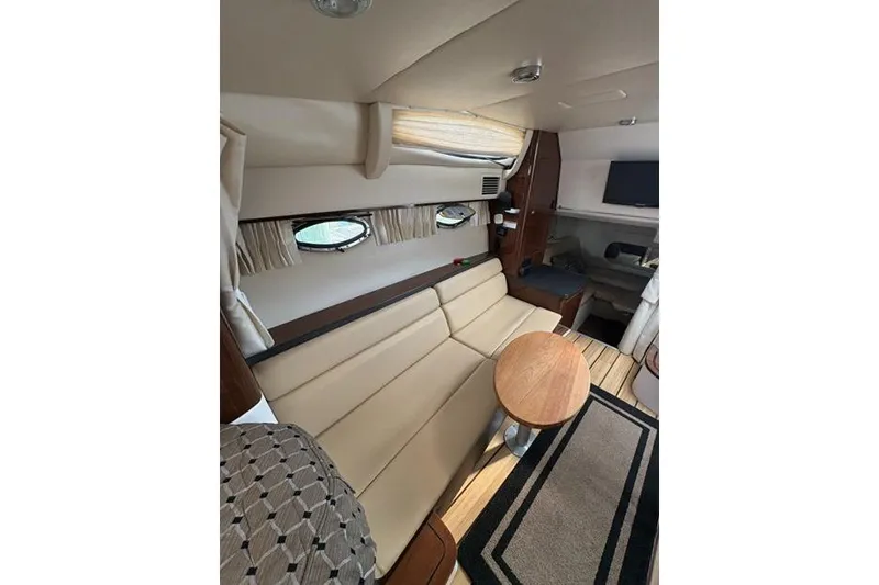 Slide: The Image of Interior of 2013 Regal 35 Express Cruiser with beige seating and wooden table. - 35