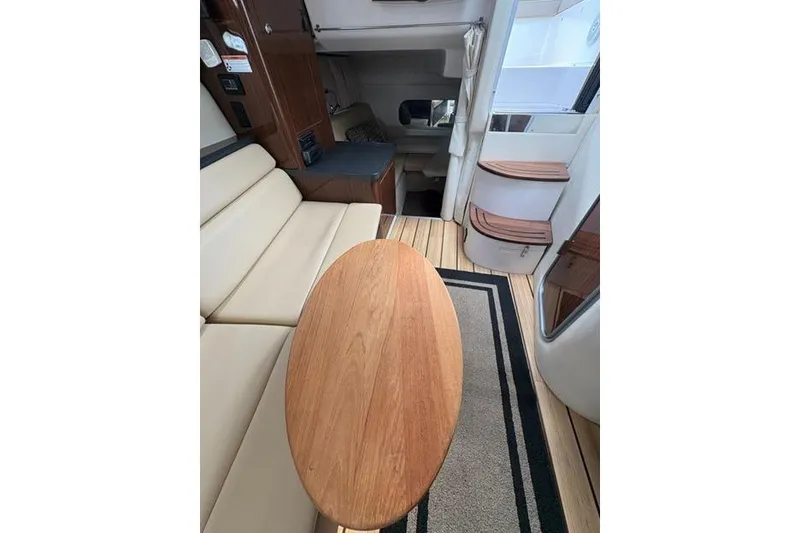 Slide: The Image of Interior of 2013 Regal 35 Express Cruiser with beige seating and wooden table. - 36