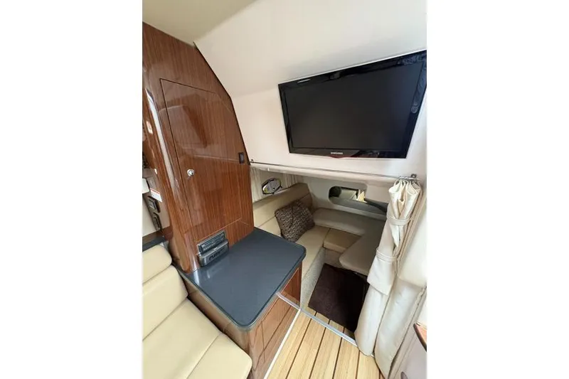 Slide: The Image of Interior of 2013 Regal 35 Express Cruiser with TV, seating, and wood paneling. - 37