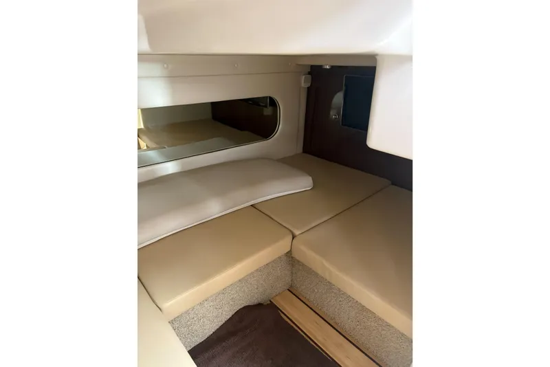 Slide: The Image of 2013 Regal 35 Express Cruiser cabin interior with beige cushions and mirror. - 45