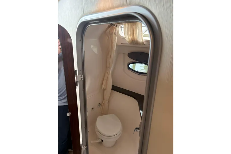 Slide: The Image of 2013 Regal 35 Express Cruiser bathroom interior with porthole and toilet. - 47