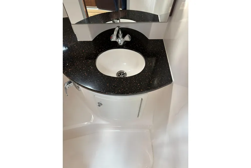 Slide: The Image of 2013 Regal 35 Express Cruiser bathroom sink with black countertop and modern faucet. - 48