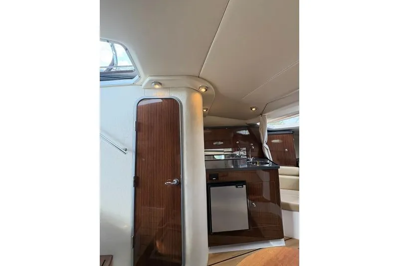 Slide: The Image of Interior of 2013 Regal 35 Express Cruiser with kitchenette and wood finish. - 53