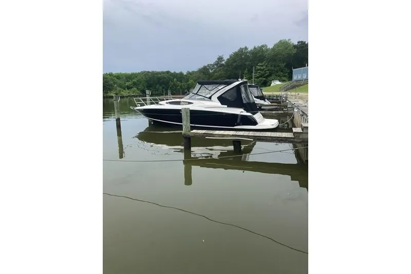 Slide: The Image of 2013 Regal 35 Express Cruiser docked on calm water, surrounded by greenery. - 6