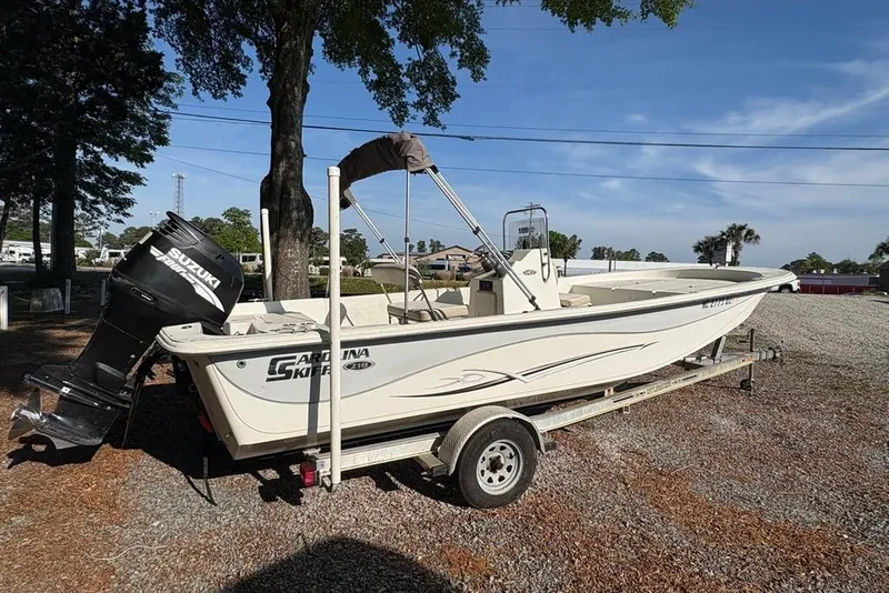 Slide: The Image of 2014 Carolina Skiff 218 DLV boat on trailer with Suzuki outboard motor. - 3