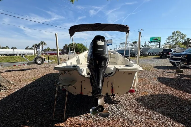 Slide: The Image of 2014 Carolina Skiff 218 DLV boat with outboard motor, parked on gravel lot. - 4