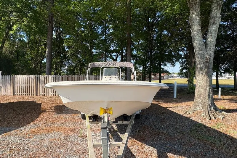 Slide: The Image of 2014 Carolina Skiff 218 DLV boat on trailer, parked in wooded area. - 8