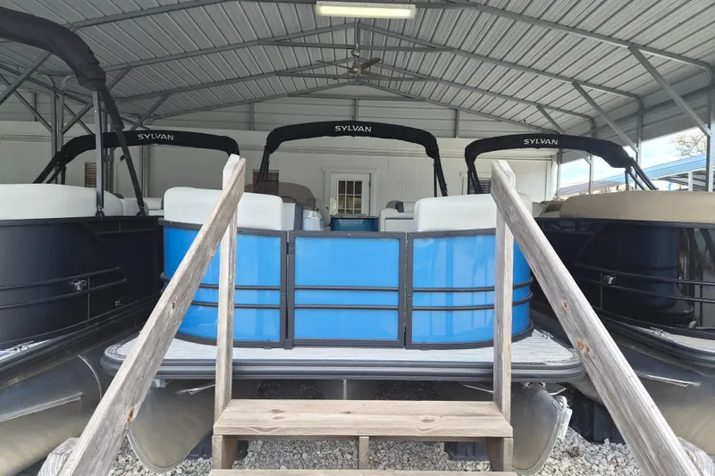 The Image of 2026 Sylvan Mirage Fish 820 Party Fish pontoon boats in a covered storage area. - 1