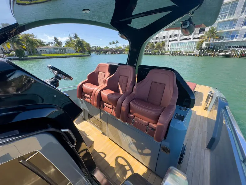 Slide: The Image of 2019 SACS Rebel 40 boat interior with luxurious seating, docked by scenic waterfront. - 12