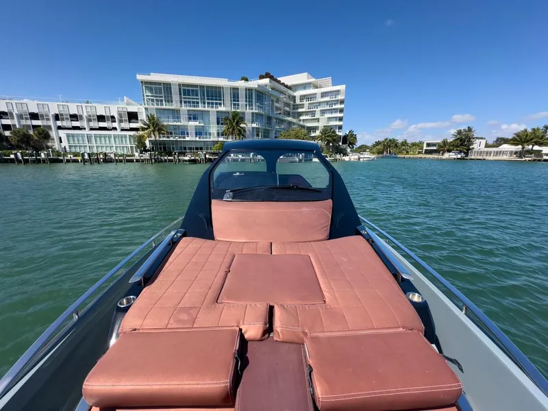Slide: The Image of 2019 SACS Rebel 40 boat with sunbed, docked near modern waterfront buildings. - 18