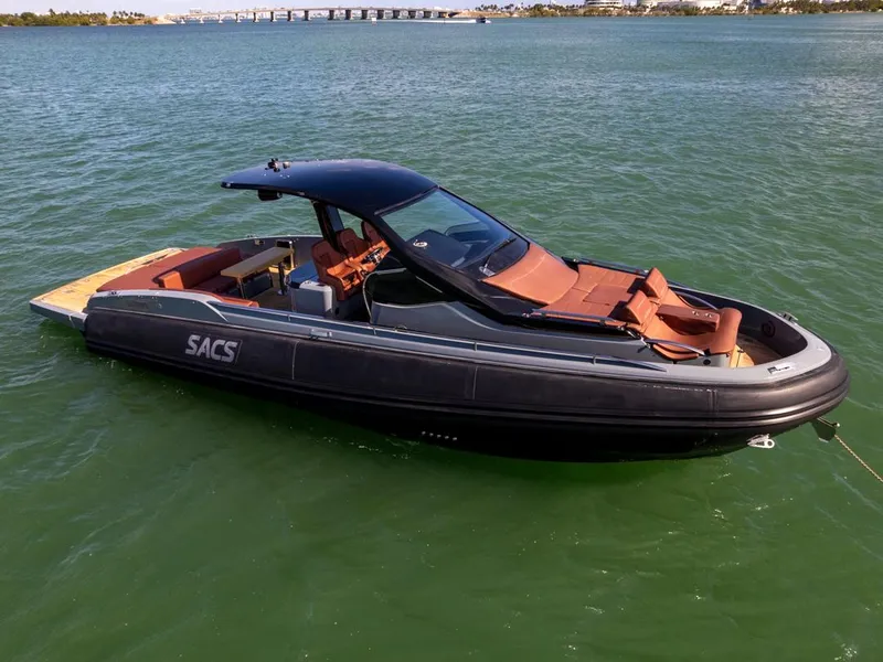 Slide: The Image of 2019 SACS Rebel 40 boat on water, sleek design, luxury seating, sunny day. - 2
