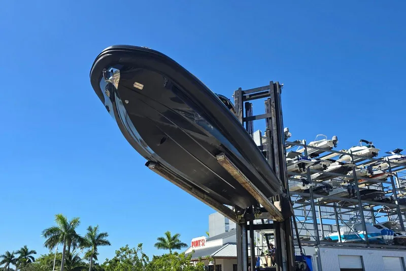 Slide: The Image of 2019 SACS Rebel 40 boat lifted by forklift against clear blue sky. - 40
