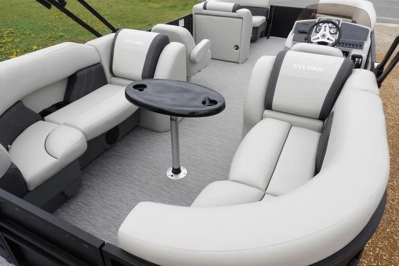 Slide: The Image of 2026 Sylvan 8522 LZ pontoon boat interior with plush seating and central table. - 30