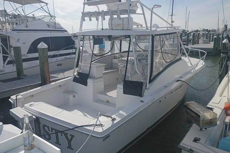 Slide: The Image of 2000 Luhrs Tournament 290 Open boat docked at marina, featuring spacious deck and fishing equipment. - 5