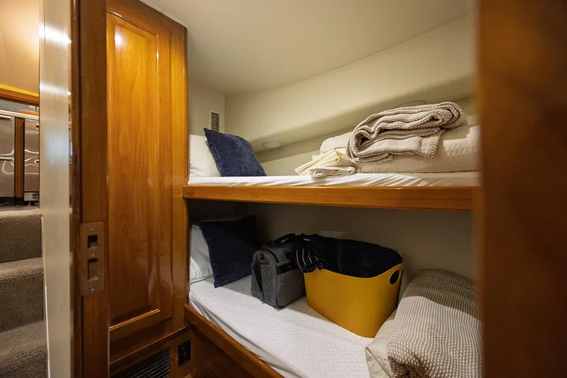 Slide: The Image of Cozy bunk beds in 1998 Viking 50 Convertible yacht cabin with wooden accents. - 14