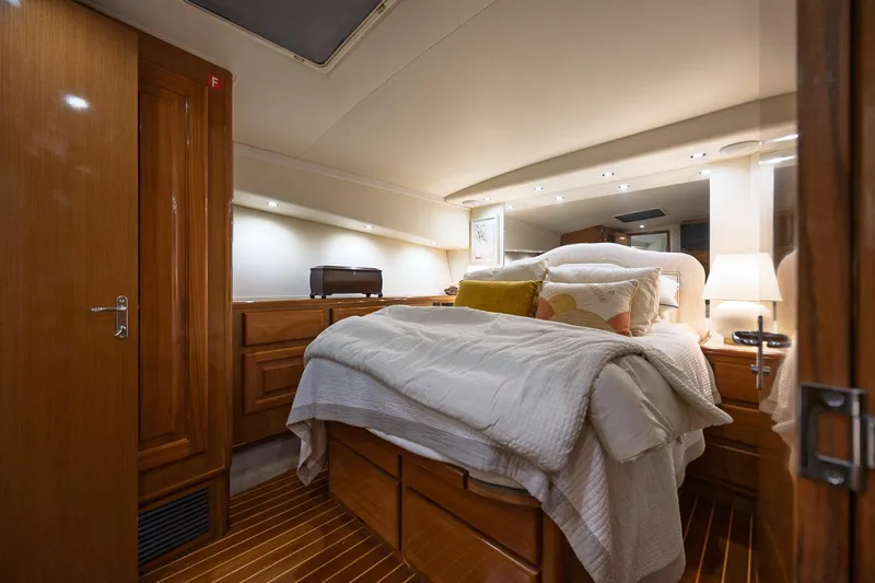 Slide: The Image of Luxurious bedroom interior of 1998 Viking 50 Convertible yacht with cozy bedding and warm lighting. - 15