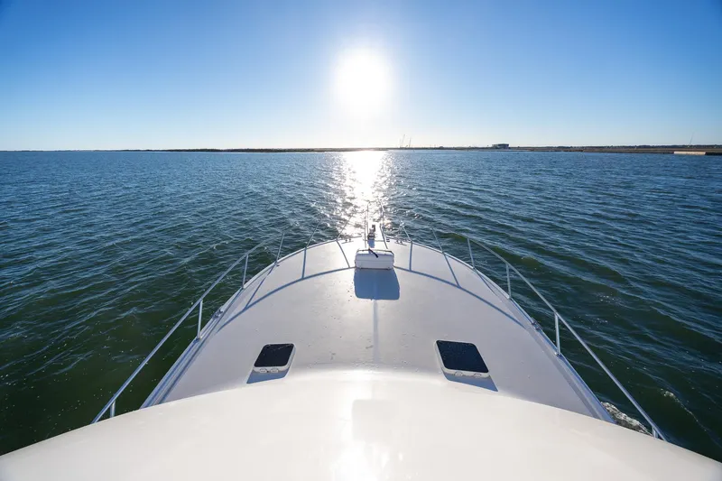 Slide: The Image of Bow view of 1998 Viking 50 Convertible yacht cruising under clear blue sky. - 22