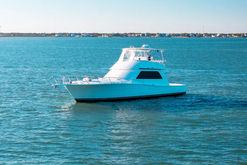 Slide: The Image of 1998 Viking 50 Convertible yacht cruising on calm blue waters. - 3