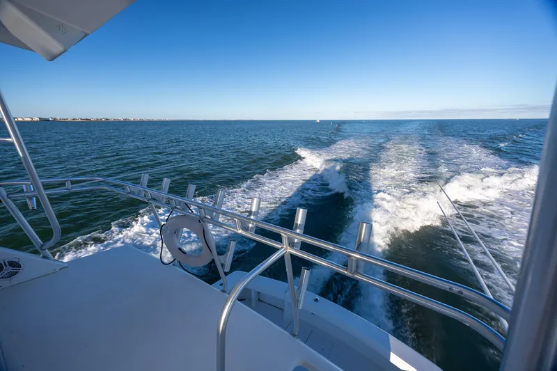 Slide: The Image of A 1998 Viking 50 Convertible yacht cruising on open water under a clear blue sky. - 37