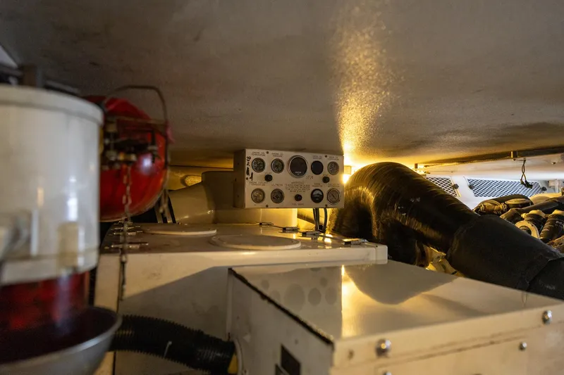 Slide: The Image of Engine room of a 1998 Viking 50 Convertible yacht, featuring control panel and equipment. - 48