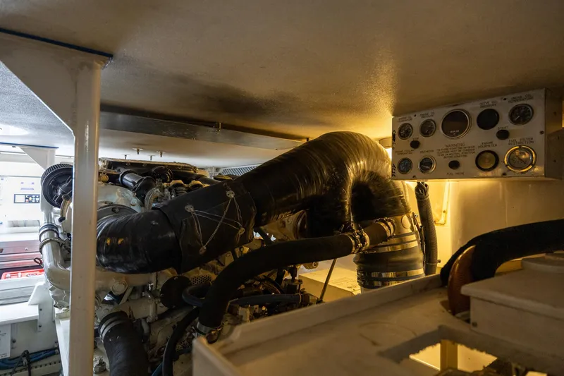 Slide: The Image of Engine room of a 1998 Viking 50 Convertible yacht, showcasing machinery and control panel. - 49