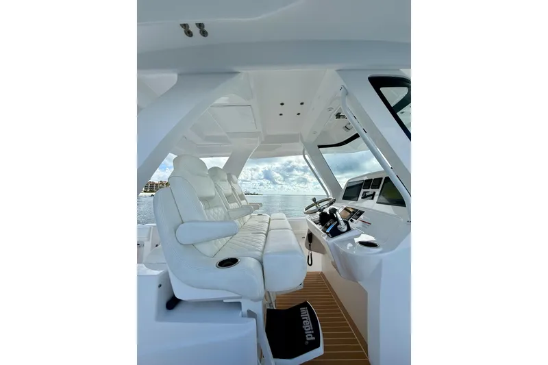 Slide: The Image of Interior view of 2022 Intrepid 407 Nomad SE boat with luxurious seating and modern controls. - 19