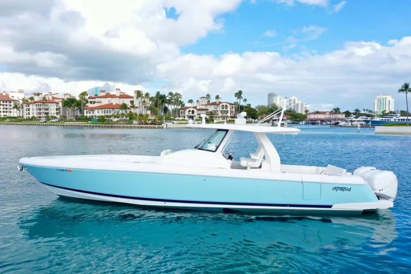 Slide: The Image of 2022 Intrepid 407 Nomad SE boat on calm water with scenic coastal backdrop. - 30