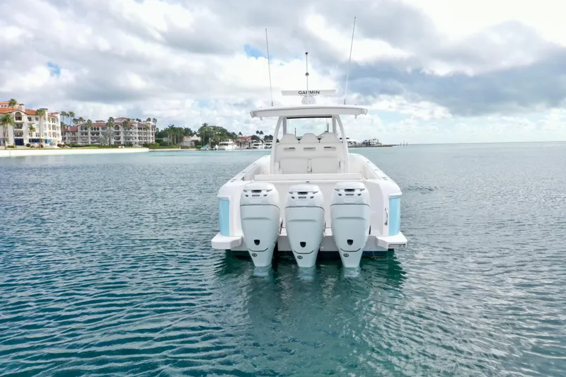 Slide: The Image of 2022 Intrepid 407 Nomad SE boat with four engines on calm water, luxury waterfront homes in background. - 4