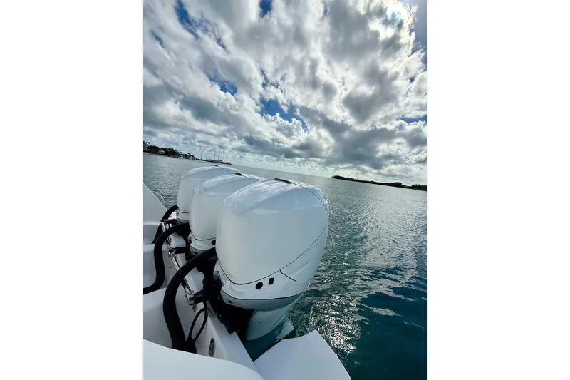 Slide: The Image of 2022 Intrepid 407 Nomad SE boat engines on calm water under cloudy sky. - 7