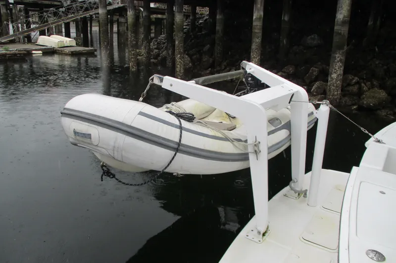 Slide: The Image of Inflatable dinghy suspended from a 1997 Mainship 350 Trawler in a marina. - 12