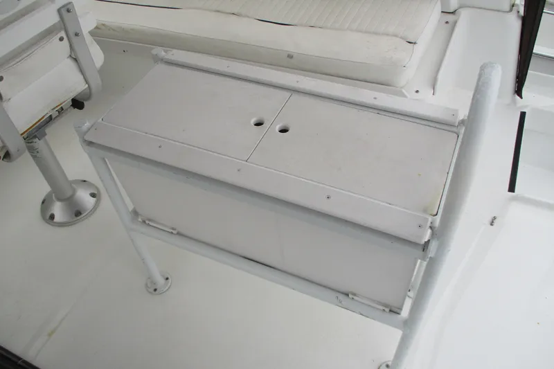 Slide: The Image of 1997 Mainship 350 Trawler interior with white seating and storage compartment. - 16