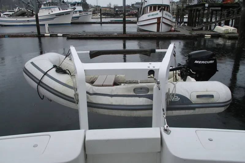 Slide: The Image of 1997 Mainship 350 Trawler with inflatable dinghy and Mercury outboard motor at marina. - 20