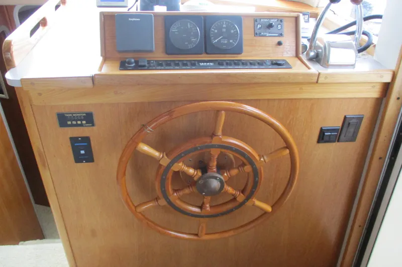 Slide: The Image of Wooden helm station of a 1997 Mainship 350 Trawler with navigation instruments. - 23