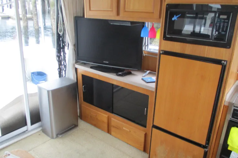 Slide: The Image of Interior of 1997 Mainship 350 Trawler with TV, microwave, and wooden cabinetry. - 25