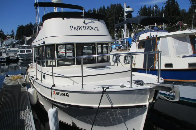 Slide: The Image of 1997 Mainship 350 Trawler docked at marina, featuring sleek design and spacious deck. - 3