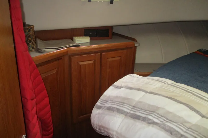 Slide: The Image of Cozy cabin interior of 1997 Mainship 350 Trawler with wooden cabinetry and bedding. - 32