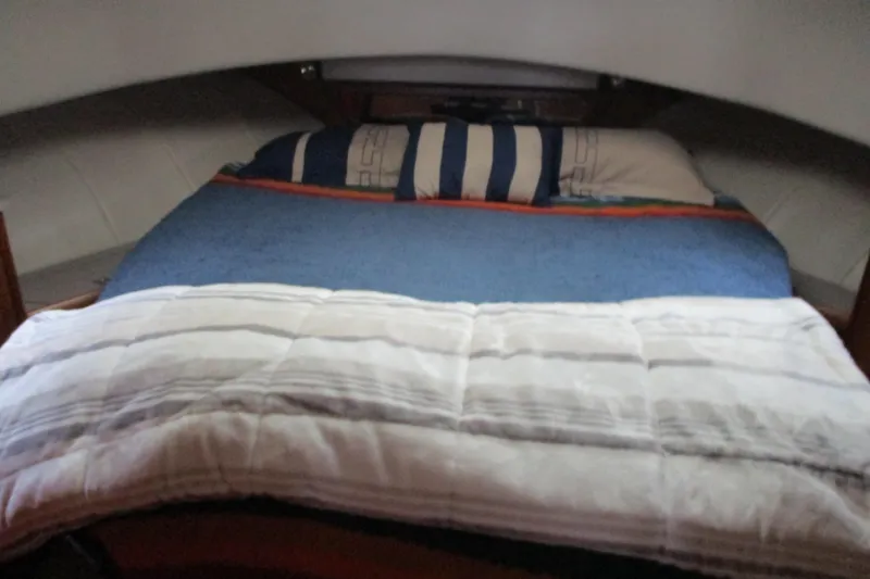 Slide: The Image of Cozy cabin bed inside a 1997 Mainship 350 Trawler, featuring striped bedding. - 33