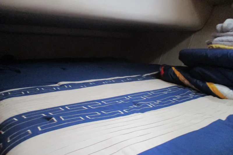 Slide: The Image of Cozy cabin bed in 1997 Mainship 350 Trawler with blue and white bedding. - 36