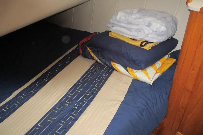Slide: The Image of Cozy cabin bed with folded blankets on a 1997 Mainship 350 Trawler. - 37
